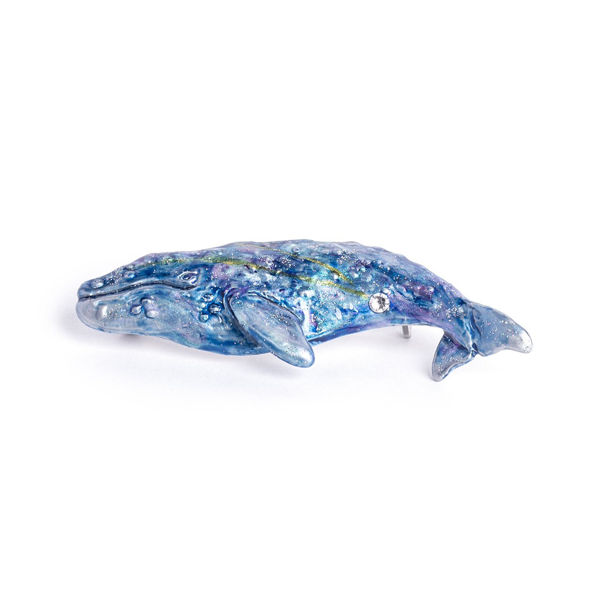 海を泳ぎながら夢をみるコククジラの体を、星空に見立ててデザインした幻想的なブローチ。